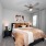 a bedroom with a large bed and a fan